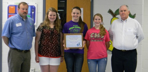 Clinton County Middle School students Jana Mullins, Chloe Martin and Olivia Maupin accepted the school’s PRIDE Environmental Education Project of the Month Award. PRIDE’s Mark Davis (left) presented the plaque, and Judge-Executive Lyle K. Huff congratulated the students on their achievement.