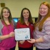 Casey County Middle School students Kayla Goad (left) and Brenna Hayes (right) accepted the school’s PRIDE Environmental Education Project of the Month Award from PRIDE’s Jennifer Johnson (center).