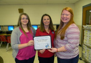 Casey County Middle School students Kayla Goad (left) and Brenna Hayes (right) accepted the school’s PRIDE Environmental Education Project of the Month Award from PRIDE’s Jennifer Johnson (center).